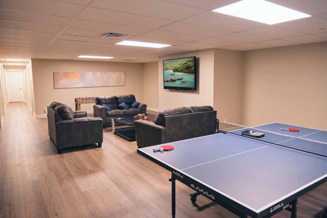 Legacy Recovery game room with ping pong table, comfortable seating area for watching TV and foosball